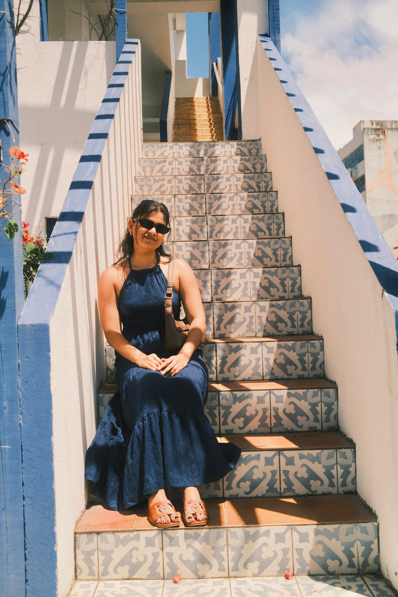 Dr. Jill Thaker sitting on patterned tiled steps in a blue dress